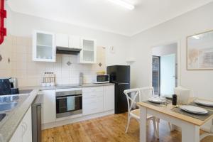 eine Küche mit Tisch und Esszimmer in der Unterkunft Family Friendly - 5 Mins To Beach in Belmont