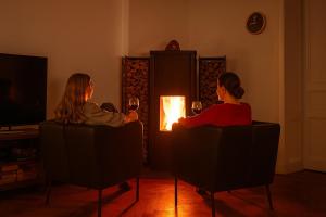 dos personas sentadas en sillas frente a un fuego en Downtown Landmark near Checkpoint Charlie - fully preserved, en Berlín