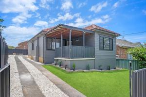 ein Haus mit einem Zaun davor in der Unterkunft Family Friendly - 5 Mins To Beach in Belmont