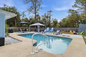 a swimming pool with chairs and a gazebo at Crystal Blue Haven in Crystal River