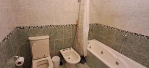 un baño con inodoro y bañera en El Encuentro, en Las Grutas 11 fotos más