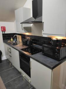 een keuken met een zwarte en witte kookplaat bij Relax Graza of Marsel in Cambridge