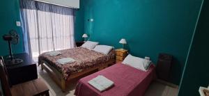 El Encuentro في لاس غروتاس: غرفة نوم بها سريرين وجدار أزرق