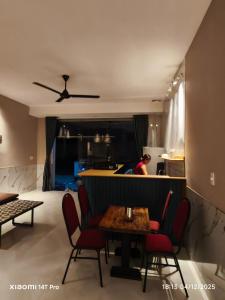 ein Zimmer mit Tisch und Stühlen und eine Küche in der Unterkunft Biệt Thự 3 Phòng Ngủ A1-03 in Ðức Hòa