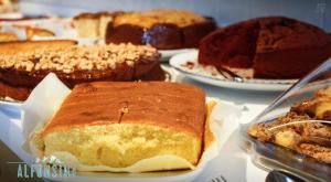 a table topped with different types of cakes on plates at Hotel La Alfonsina in Santibáñez de Villacarriedo