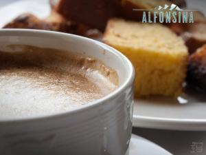 a cup of coffee next to a plate of bread at Hotel La Alfonsina in Santibáñez de Villacarriedo