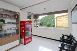 a coca cola machine in a room with a window at Hotel Lestari Near Lippo Plaza Mall Jember in Jember