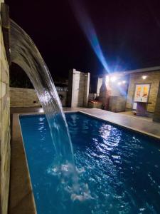 a swimming pool at night with a water fountain at Casa Harmonia in Aracaju