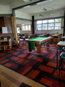 a pool table in a room with tables and chairs at Cosmopolitan Hotel, pub, restaurant and gaming room in Westport