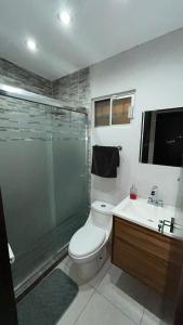 Un baño con ducha, inodoro y lavabo. en Bonita casa de lujo, en Ciudad Obregón