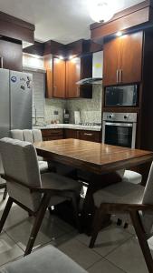 Una cocina con una mesa de madera y algunas sillas. en Bonita casa de lujo, en Ciudad Obregón