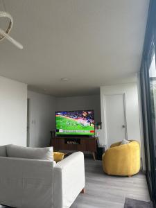 een woonkamer met een bank en een flatscreen-tv bij Luxury Duplex on the 15th Floor with Terrace in Lima
