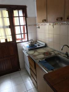 een keuken met een spoelbak en een fornuis bovenste oven bij Complejo Las Tonas in Las Toninas