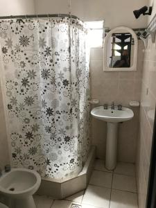 een badkamer met een douchegordijn en een wastafel bij Complejo Las Tonas in Las Toninas +26 foto's