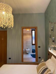 a bedroom with a bed and a mirror and a bathroom at Centro Storico Suites Sarnico in Sarnico