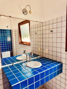Baño de azulejos azules con 2 lavabos y espejo en Pousada Casa Palo, en Itacaré