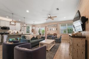 een woonkamer met banken en een keuken bij Coral Dreams-Luxe Cottage steps from the Beach & Pool! in Gulf Shores