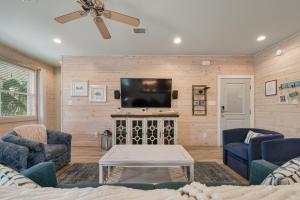 a living room with a tv and two chairs and a table at PRIME Coral Dreams Walk to Beach Pool Pets Near The Hangout Parking in Gulf Shores