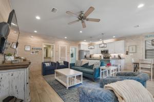 a living room with blue furniture and a kitchen at PRIME Coral Dreams Walk to Beach Pool Pets Near The Hangout Parking in Gulf Shores