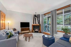 a living room with a couch and a tv at 2BR Very Spacious Townhome in a Great Location by Harmony Whistler in Whistler