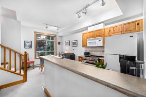a kitchen with a counter and a refrigerator at 2BR Very Spacious Townhome in a Great Location by Harmony Whistler in Whistler