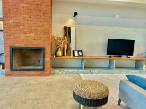 a living room with a fireplace and a tv at Casa La Vigie in Águas de Lindoia