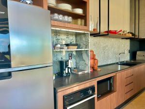 a kitchen with a stainless steel refrigerator at Casa La Vigie in Águas de Lindoia