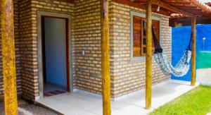 a brick house with a door and a porch at Morada do vento in São Miguel do Gostoso