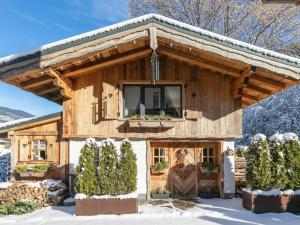 a log cabin in the snow with a window at Almversteck Hollersbach in Hollersbach im Pinzgau