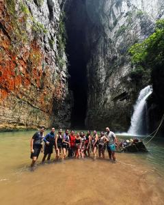 un grupo de personas de pie en el agua cerca de una cascada en Centro ecoturistico Arco del Tiempo, en Cintalapa de Figueroa