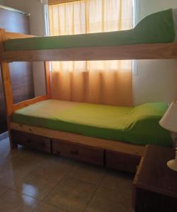 een stapelbed met een groene matras erop bij Complejo llaipen 2 confirmar reserva luego de la solicitud desde la app! in Las Grutas
