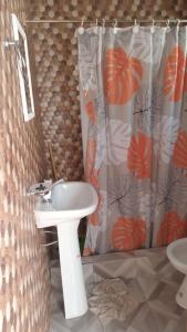 een badkamer met een wastafel en een douchegordijn bij Complejo llaipen 2 confirmar reserva luego de la solicitud desde la app! in Las Grutas