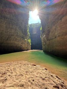 Una vista de una playa con el sol en una cueva. en Centro ecoturistico Arco del Tiempo, en Cintalapa de Figueroa