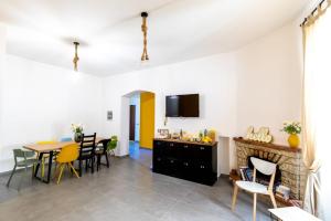 a dining room with a table and chairs and a tv at Mira Vietri in Vietri sul Mare