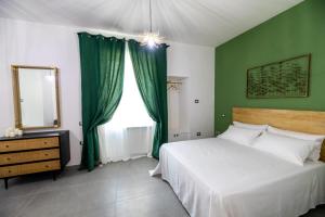 a bedroom with a bed with green walls and a mirror at Mira Vietri in Vietri sul Mare