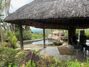 Cabaña con mesa, sillas y piscina en Hooggelegen Estate, en White River