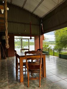 Un comedor con mesa y sillas de madera. en Departamento con vista al lago, en Puerto Libertad