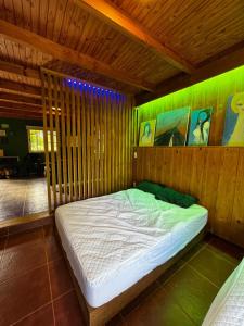 Un dormitorio con una cama en una habitación de madera. en Departamento con vista al lago, en Puerto Libertad