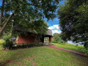 un edificio de ladrillo rojo con un árbol al lado en Departamento con vista al lago, en Puerto Libertad