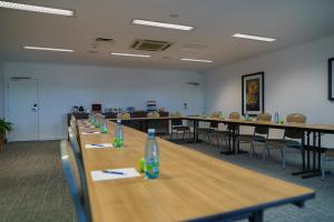 MainStay Suites Whyalla في وايالا: غرفة بها صفوف من الطاولات والكراسي +38 صورة