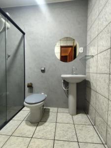 un bagno con un water, un lavandino e uno specchio di Apartamento Zen Residencial Isaura a Rio Branco