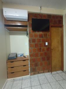 un muro di mattoni con una TV a schermo piatto di Apartamento Zen Residencial Isaura a Rio Branco