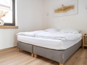 Holiday home Ahorn ground floor في Weilerswist: سرير في غرفة عليها شراشف بيضاء