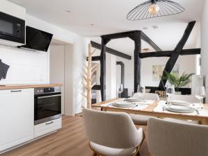 Holiday home Ahorn ground floor في Weilerswist: مطبخ وغرفة طعام مع طاولة وكراسي