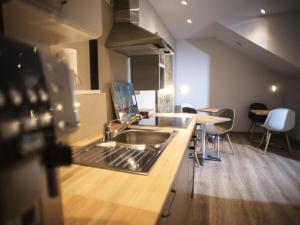 uma cozinha com um lavatório e um balcão com cadeiras em Apartment DOVE CAGE AD1710 em Marktheidenfeld mais 13 fotografias