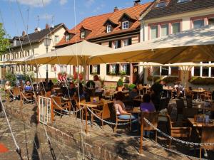 um grupo de pessoas sentadas em um restaurante sob guarda-chuvas em Apartment DOVE CAGE AD1710 em Marktheidenfeld