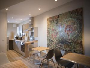 uma cozinha com mesas e cadeiras e um grande quadro na parede em Apartment DOVE CAGE AD1710 em Marktheidenfeld