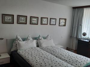 a bedroom with a bed with pillows and pictures on the wall at Holiday apartment Constantin in Davos