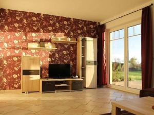 Holiday home in Schaprode with barbecue في Charlottendorf: غرفة معيشة فيها تلفزيون وجدار