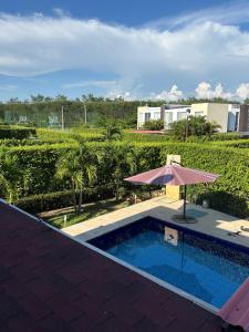 uma piscina com um guarda-sol ao lado de um edifício em Casa moderna con piscina privada Cabo Verde praia em Ricaurte